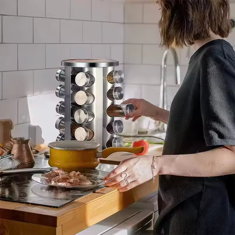 Clarify.pk stainless steel rotating spice rack in kitchen with person using spice jar near stove