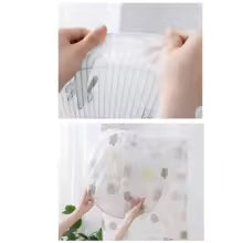 Clear flexible stand fan protective cover being stretched and installed over a fan to prevent dust and damage