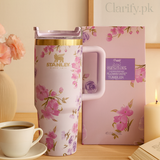 Stanley floral insulated tumbler with pink and purple flower design and gold accents next to matching box on wooden table