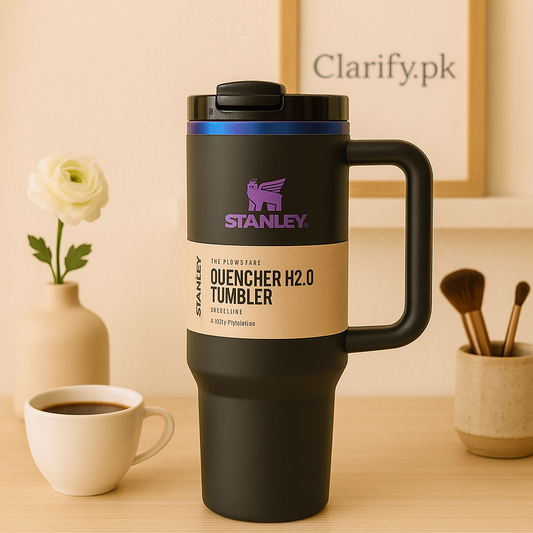 Stanley quencher black edition travel tumbler with handle on wooden table next to cup of coffee and flower