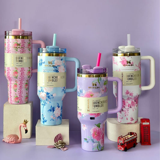 Colorful stainless steel flower tumbler set with floral designs and lids on display by Clarify.pk