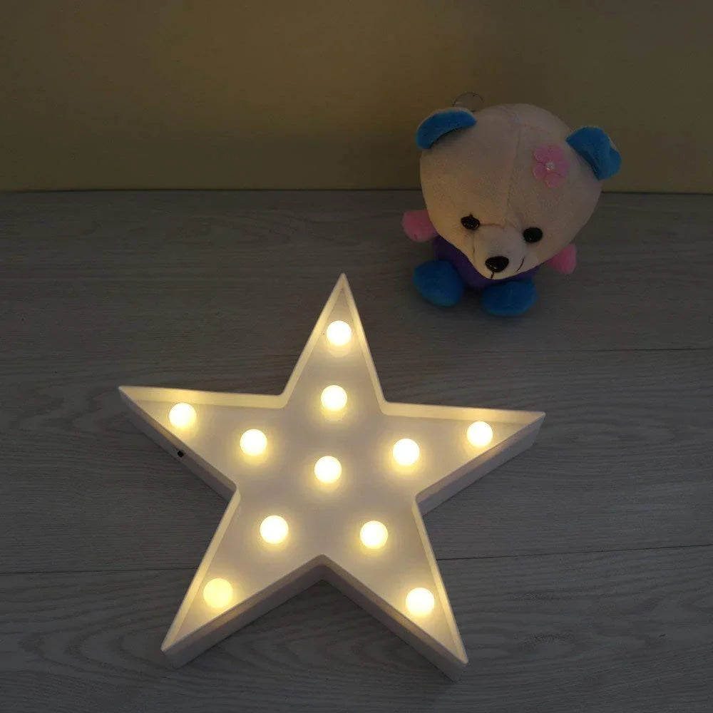 Clarify.pk star shape LED night lamp glowing on wooden floor with plush bear in background