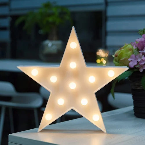 Clarify.pk star shape LED night lamp glowing warmly on a table in a cozy room setting