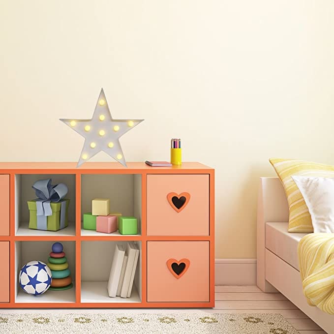 Star shape LED night lamp on orange cubby shelf in a cozy children's room with toys and bed