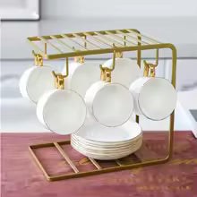 Stylish coffee mugs holder from Clarify.pk with gold metal frame and white ceramic mugs hanging