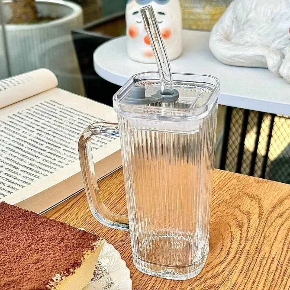 Stylish square glass mug with a straw and ribbed design on a wooden table