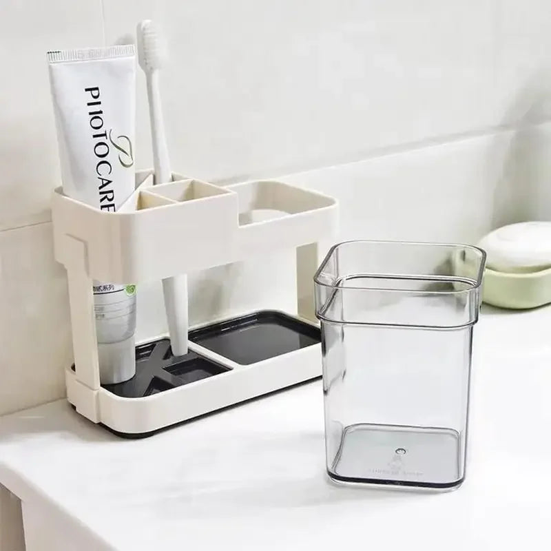 White toothbrush organizer with multiple compartments holding toothpaste and toothbrush on bathroom counter