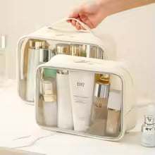 Clarify.pk transparent makeup bag with beige trim holding various cosmetic bottles and tubes