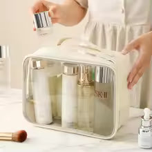 Clarify.pk transparent makeup bag with white trim holding skincare and cosmetic bottles