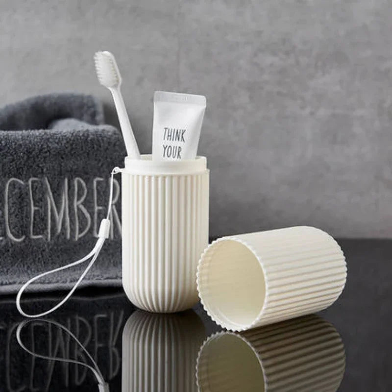 White ribbed travel toothpaste storage case holding toothbrush and toothpaste tube on black surface