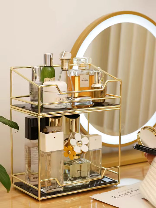 Gold metal desktop makeup organizer rack with multiple compartments holding perfume bottles and cosmetics
