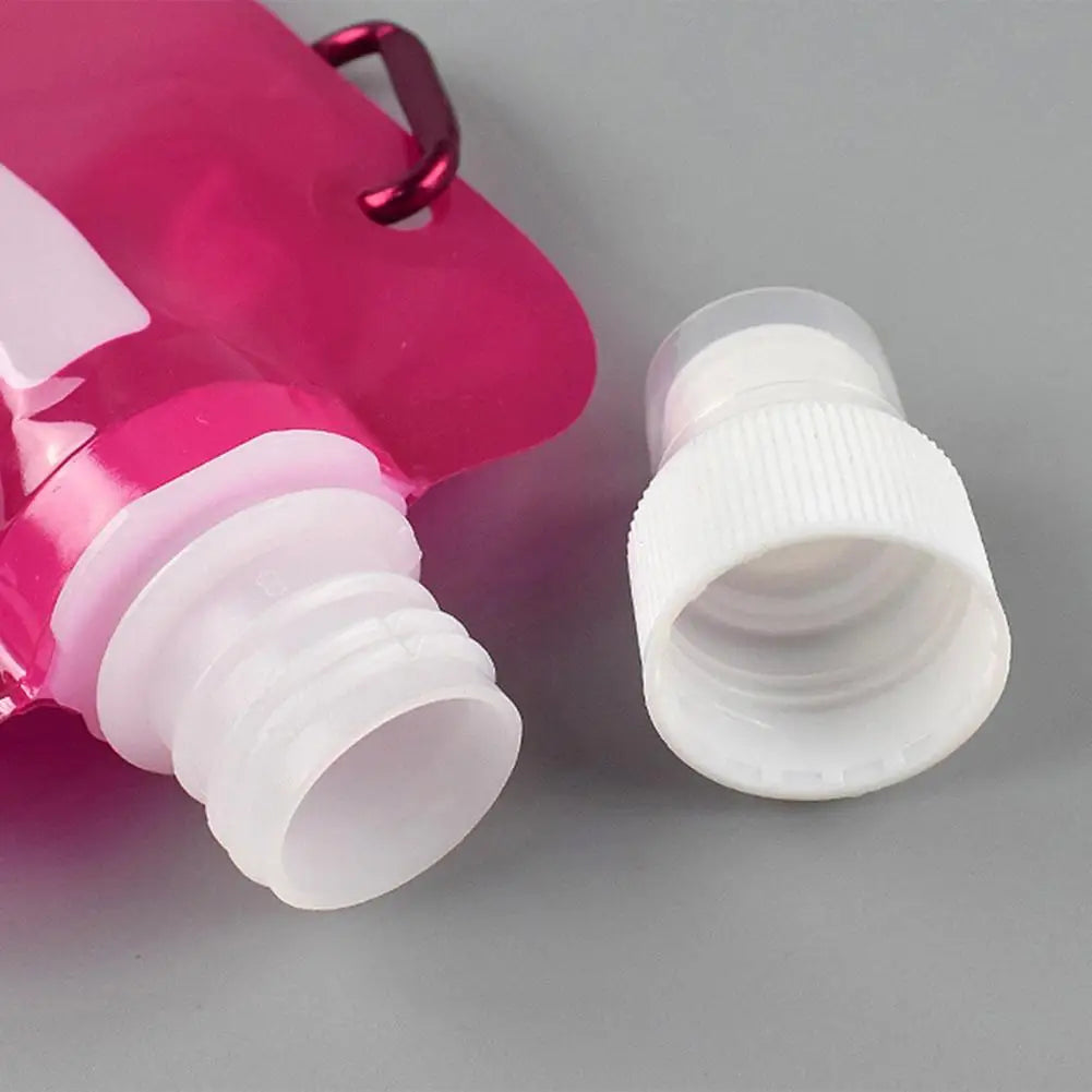 Pink ultralight foldable water container with white screw cap detached on gray background