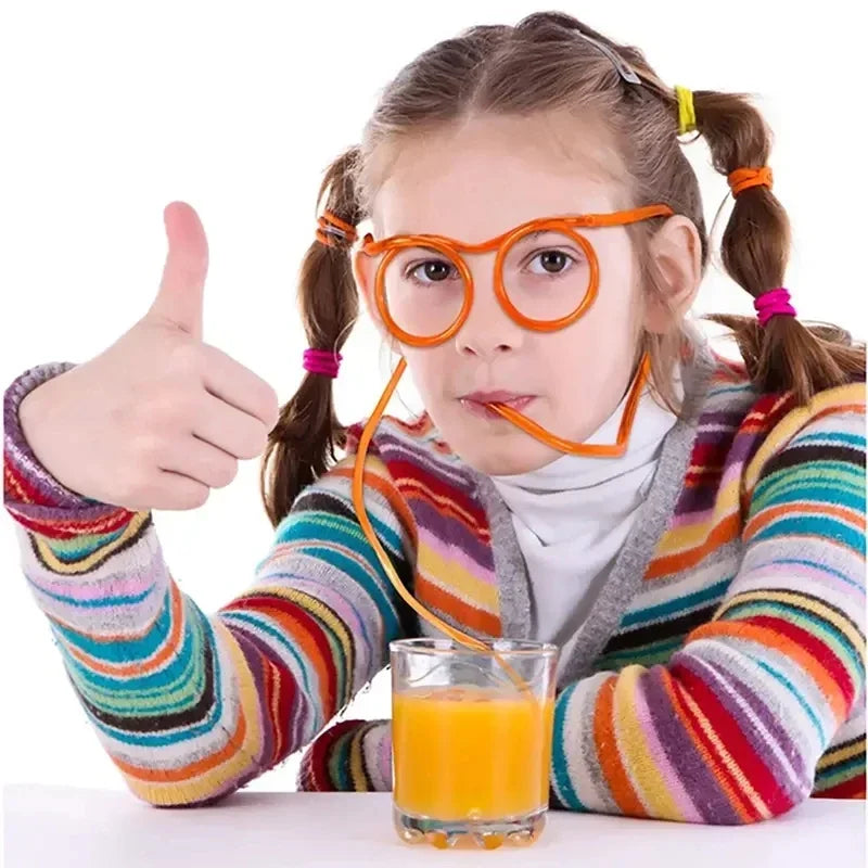 Girl wearing glasses with orange unique drinking straws drinking orange juice and showing thumbs up