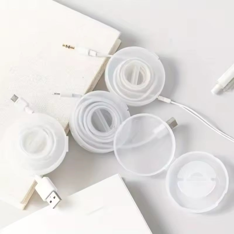 Clear round data cable storage box with white cables neatly coiled inside on a white surface