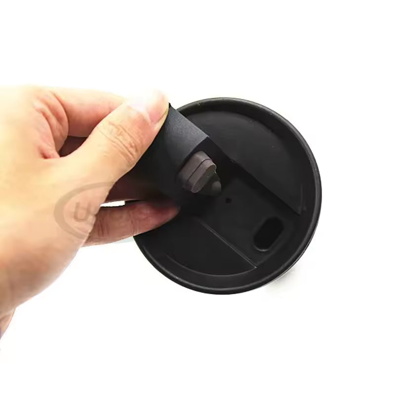 Hand holding a black lid of a 500ml insulated travel mug showing the drinking spout and seal
