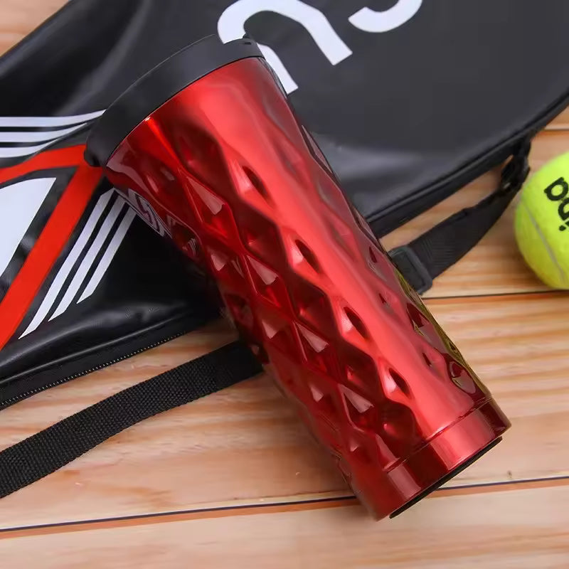 Clarify.pk 500ml insulated travel mug in shiny red with textured body and black lid on wooden surface