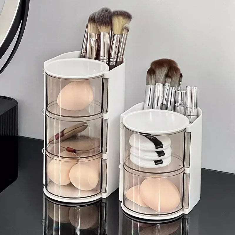 White 3 layer cosmetic storage box holding makeup brushes and sponges on black surface