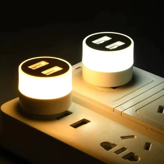 Clarify.pk portable mini night light with dual USB ports plugged into power strip emitting warm and cool light