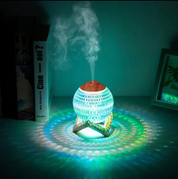 USB portable fragrance diffuser emitting mist with colorful LED lights on wooden stand
