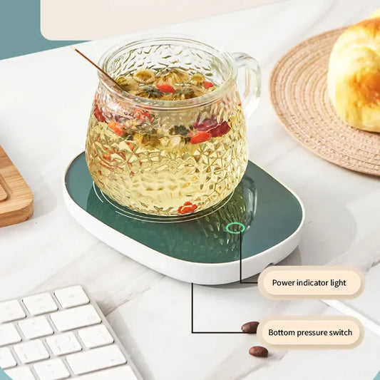 USB powered cup heater with power indicator light and bottom pressure switch warming a glass cup of herbal tea