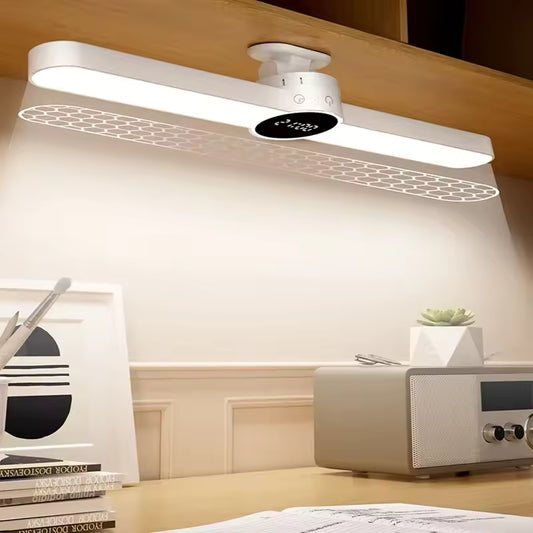 USB rechargeable LED desk lamp mounted under a wooden shelf illuminating a workspace with books and a speaker