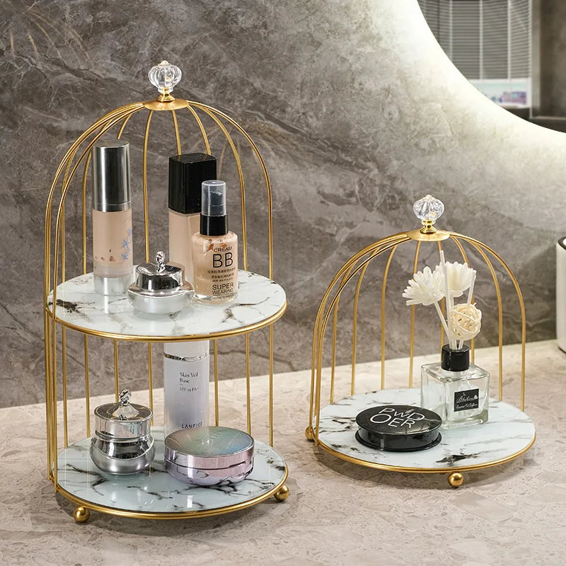 Clarify.pk 2 tier cosmetic storage rack with gold metal frame and marble shelves holding makeup and perfume bottles