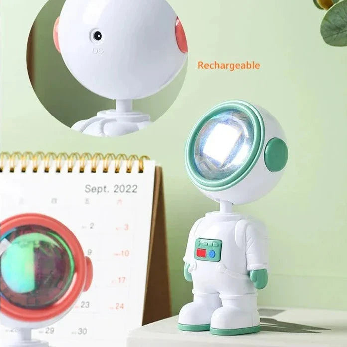 Rechargeable astronaut starry sunset lamp with glowing helmet placed on white surface next to calendar