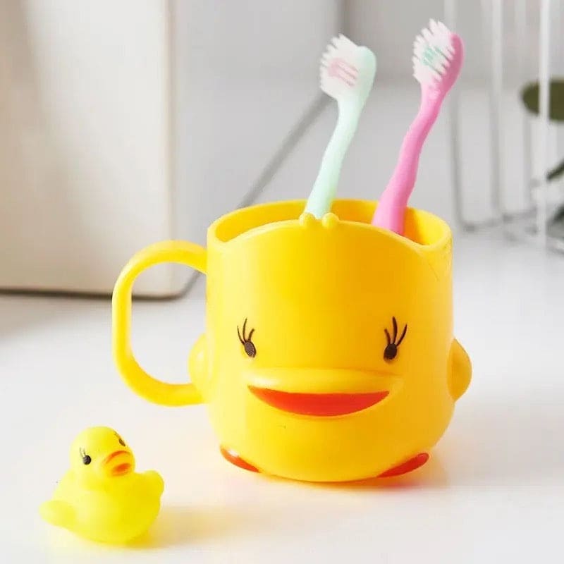 Cute duck toothbrush cup in yellow holding two toothbrushes with small rubber duck beside it
