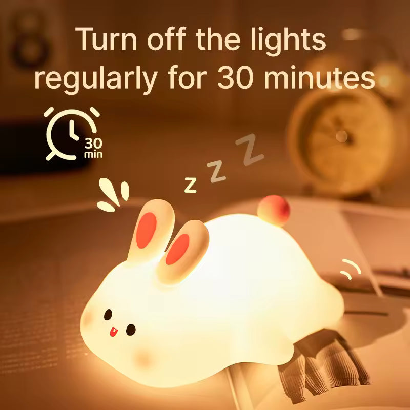 Cute rabbit desk lamp glowing warmly on a nightstand with soft ambient light