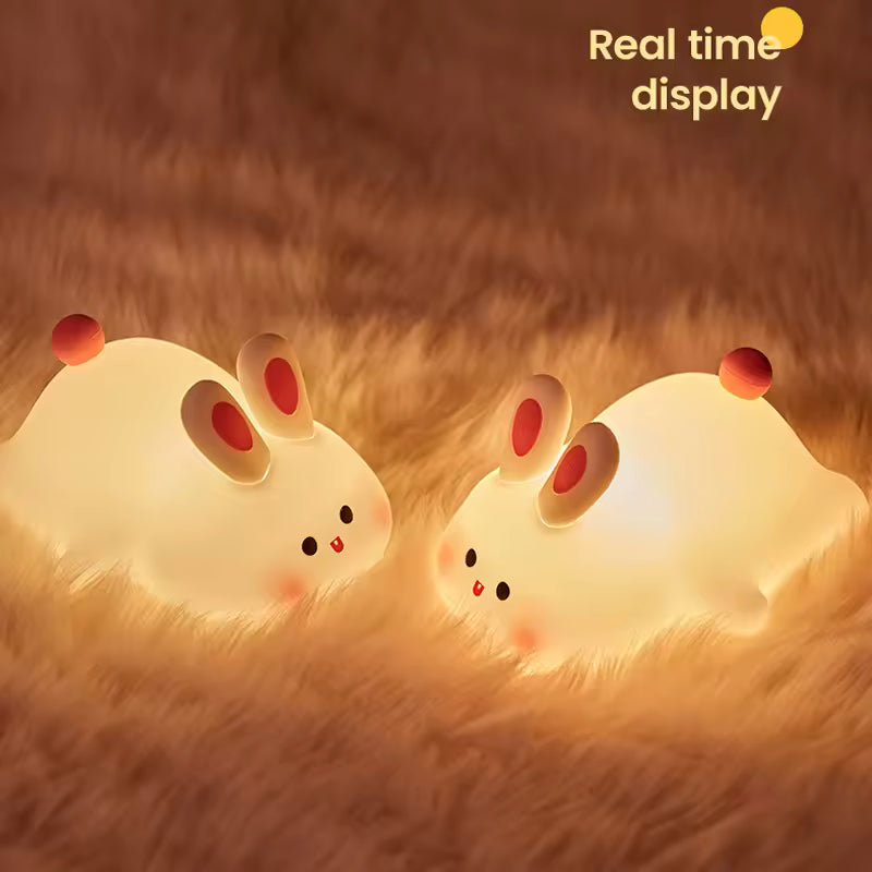 Two cute rabbit desk lamps glowing softly on a fuzzy brown surface with real time display text