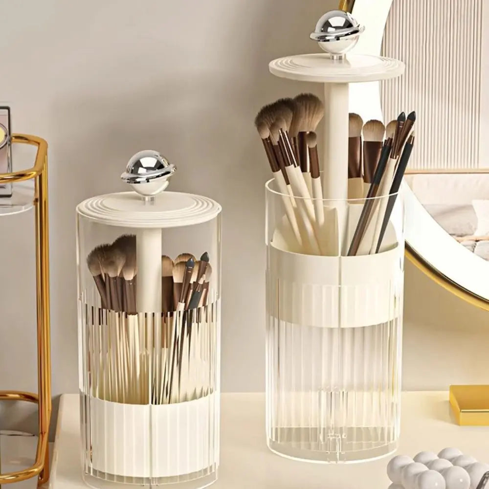 Clear dustproof makeup brush holder with white and gold accents holding various makeup brushes on vanity
