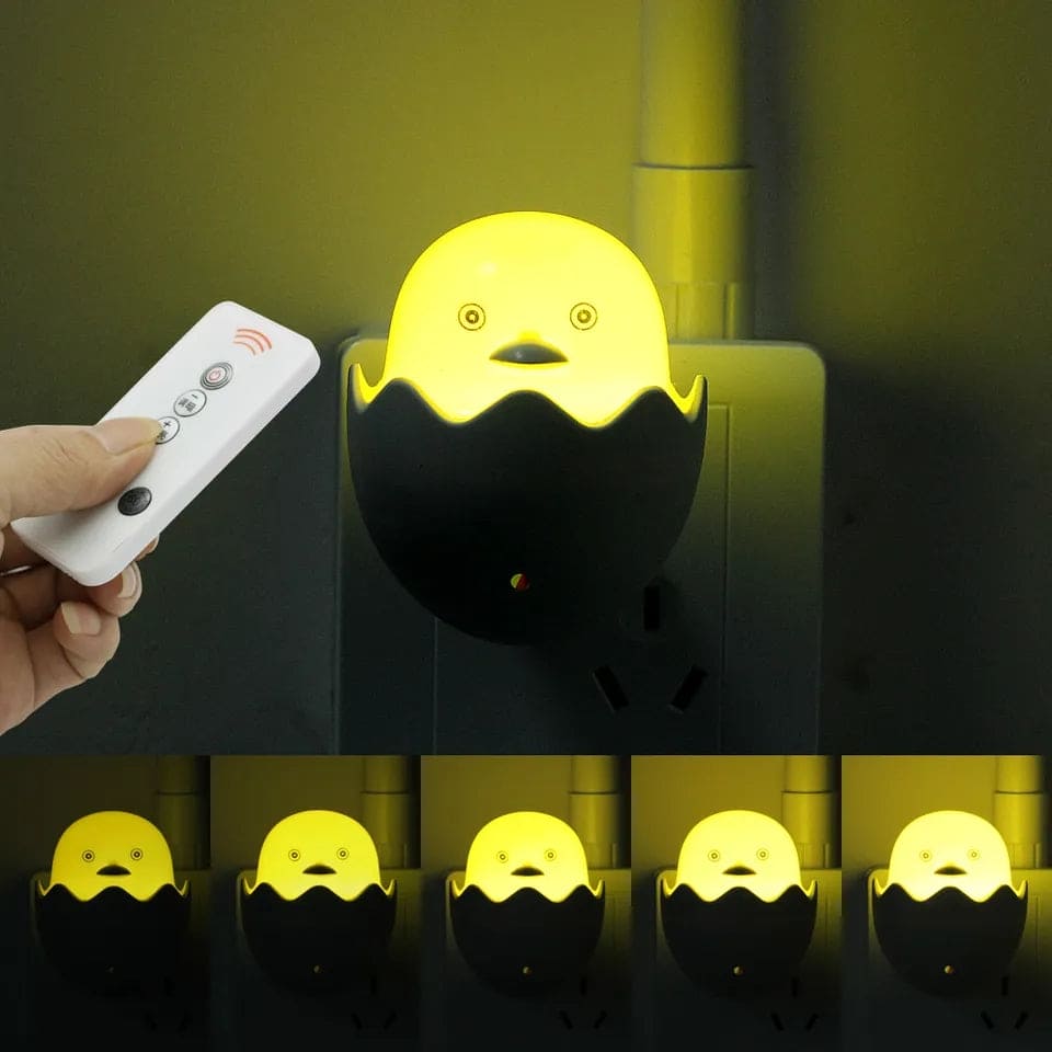 Egg shell night lamp for bedroom glowing yellow with remote control and black base plugged into wall outlet
