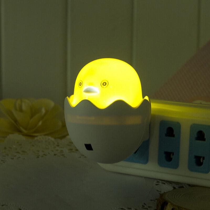 Egg shell night lamp for bedroom shaped like a glowing yellow chick in cracked egg design