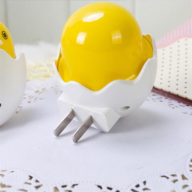 Yellow and white egg shell night lamp for bedroom with plug-in design on a lace surface