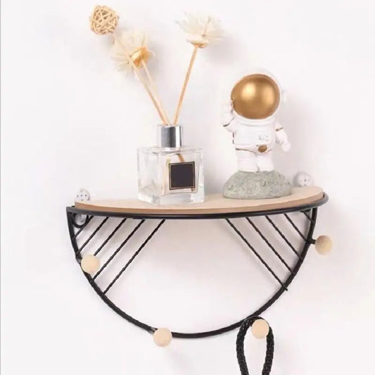 Floating wall shelf for decor with black metal frame and wooden top holding astronaut figurine and diffuser