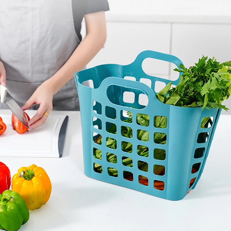 Foldable plastic laundry basket in blue filled with fresh vegetables on kitchen counter