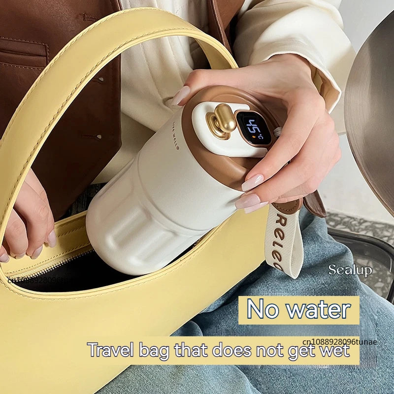 Premium coffee mug with digital temperature display being placed inside a yellow travel bag
