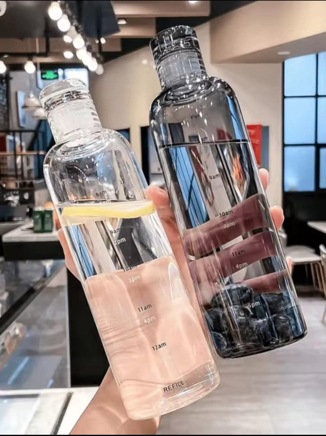 Two transparent plastic water bottle 500ml with measurement markings held in hand indoors