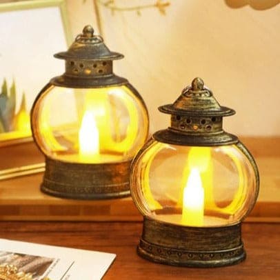 Antique style electronic candle lantern for home decor with warm glowing light on wooden surface
