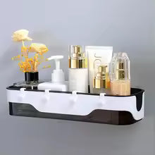 Black and white wall-mounted bathroom shelf holding toiletries and decorative flowers