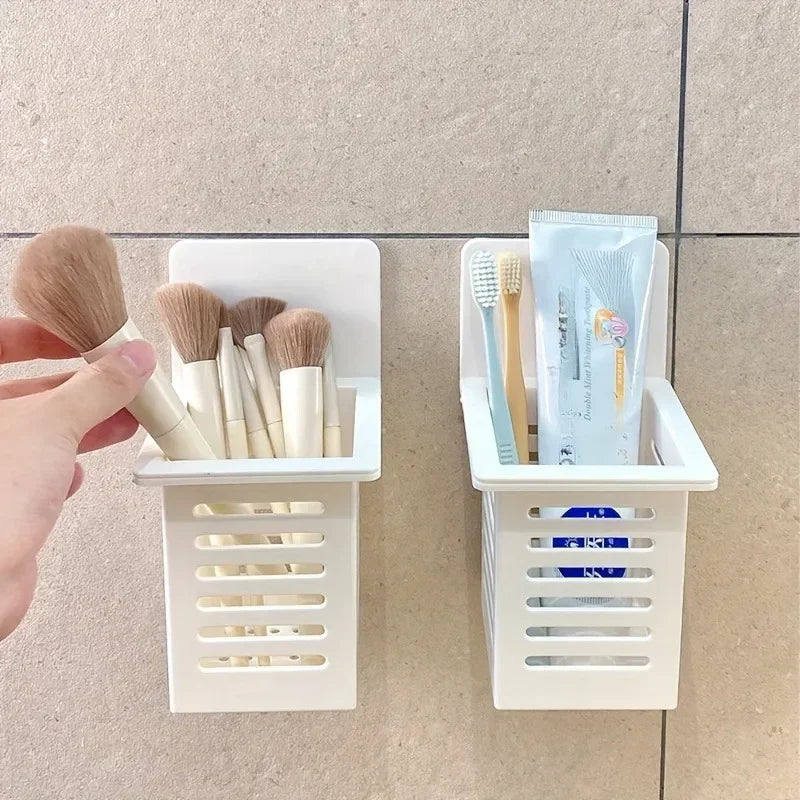 White wall mounted organizer holding makeup brushes and toothbrushes with toothpaste on tiled wall
