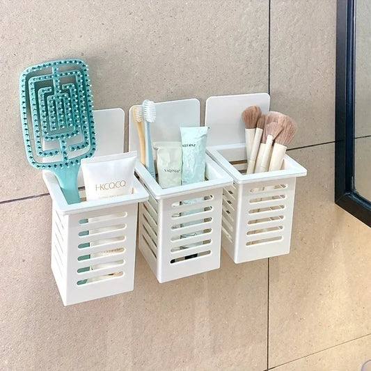 White wall mounted organizer with three compartments holding brushes toothpaste and makeup tools