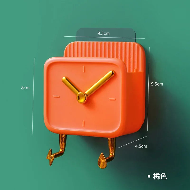 Orange wall mounted storage box shaped like a clock with gold hands and supporting legs