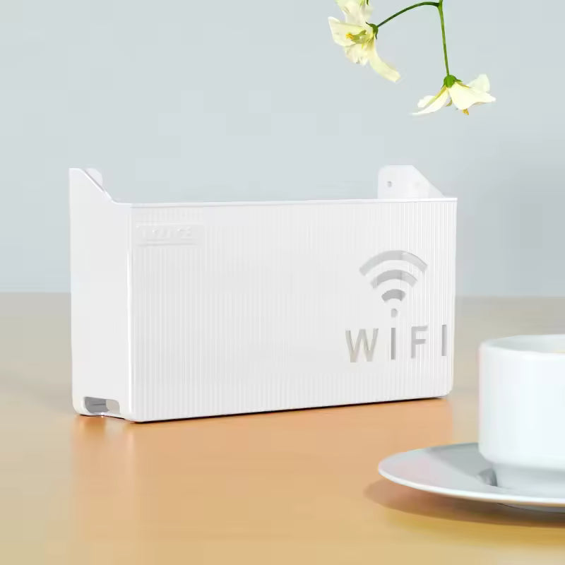 White wall mounted wifi router box with WiFi symbol placed on a wooden surface next to a cup and flowers