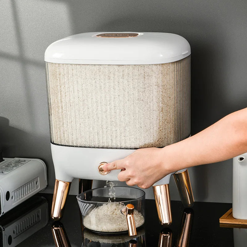 Clarify.pk automatic grain dispenser for kitchen with white body and gold legs dispensing grain into a bowl