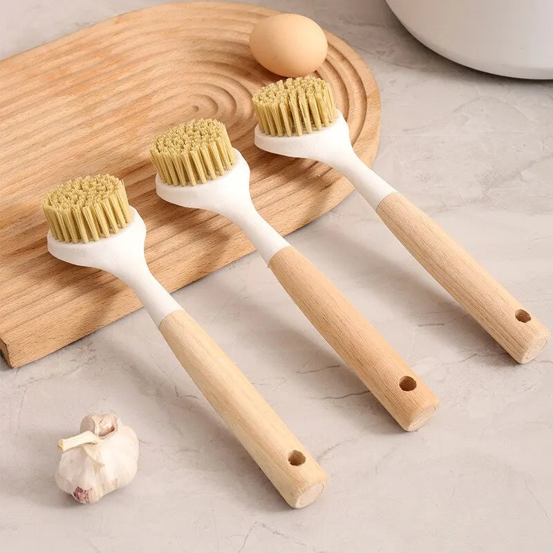 Set of three wooden handle dishwashing brush with tan bristles on a kitchen countertop