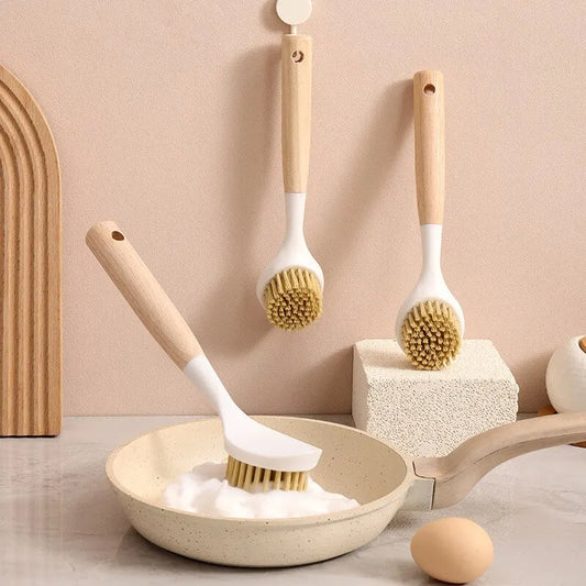 Wooden handle dishwashing brush with firm bristles cleaning a pan filled with soap foam