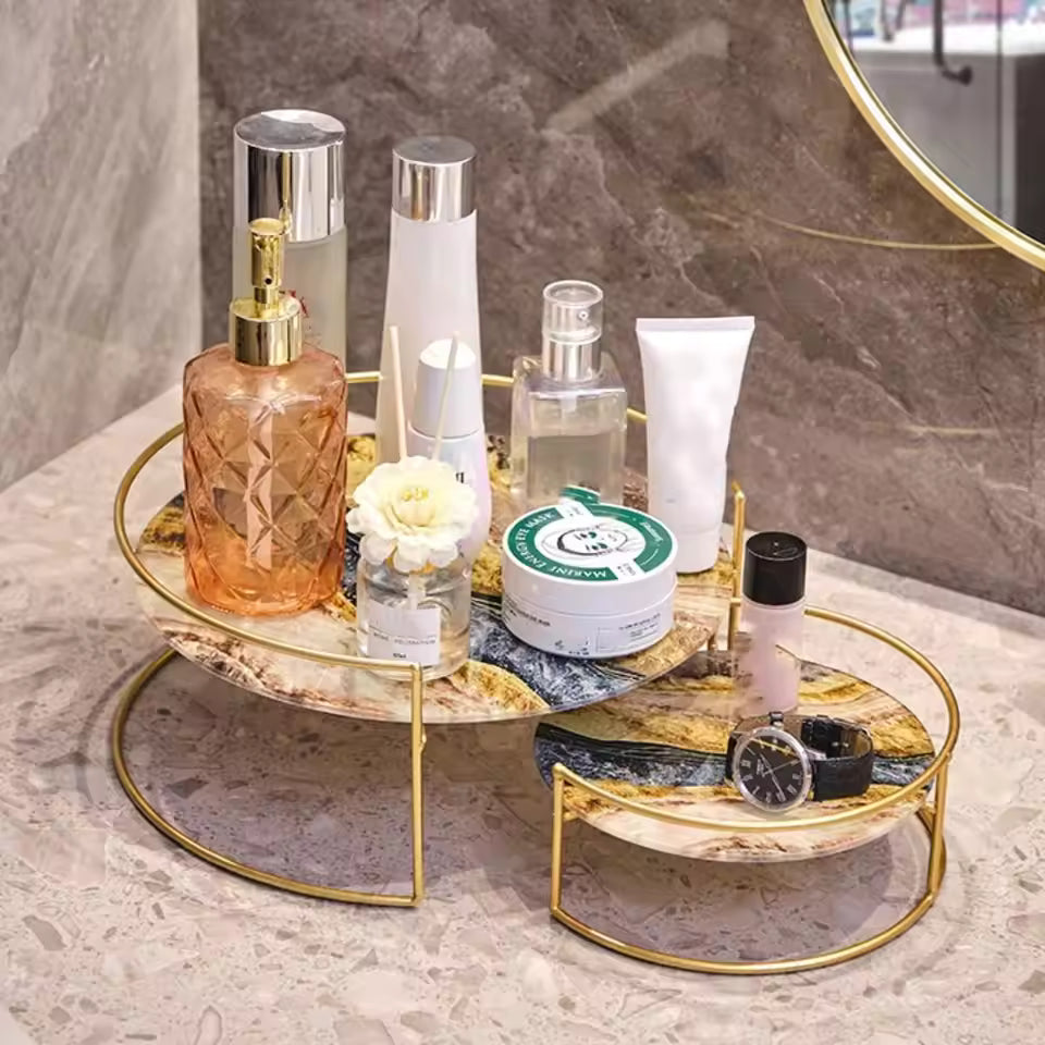Clarify.pk wrought iron storage rack with gold frame and marble shelves holding skincare and cosmetic items