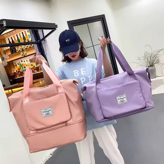 Woman holding two large capacity travel bags in pink and purple by Clarify.pk in a modern room