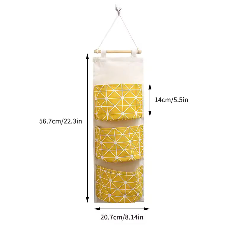 Clarify.pk hanging wall storage organizer with three yellow geometric pattern pockets and wooden hanger